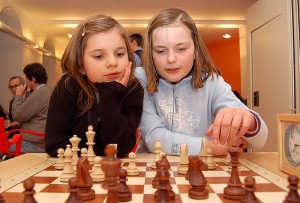 Zwei Mädchen überlegen zusammen ihren nächsten Schachzug.