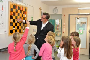 Schach-Förderer Roman Krulich diskutiert mit den Kindern der Klasse 2 a spannende Spielvarianten