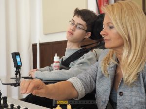 Stiftungsvorsitzende Dijana Dengler assistiert einem jungen Schachspieler mit Behinderungen.