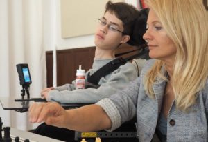 Stiftungsvorsitzende Dijana Dengler assistiert einem behinderten Schachspieler in der Landesschule